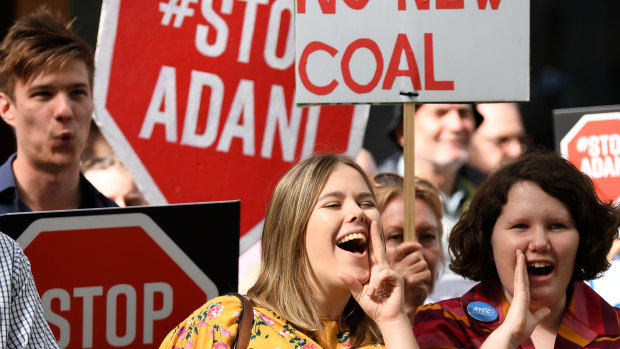 Anti-Adani protesters hold placards  in Brisbane