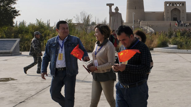 Chinese national flags on the hands of minorities who are on a patriotic tour to Ermin Minaret in Turpan City, Xinjiang Uyghur Autonomous Region, China last month.