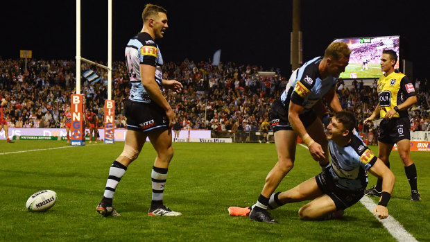 Hero of the day: teammates mob Bronson Xerrri after one of his three tries for Cronulla.