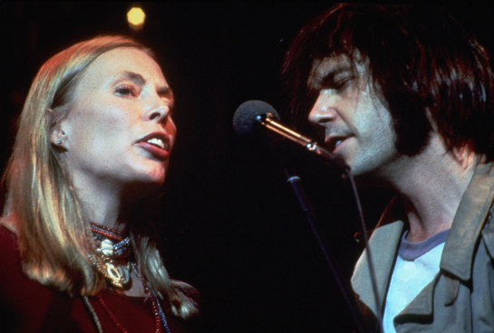 Joni Mitchell and Neil Young perform with The Band in 1976, captured in the film The Last Waltz.