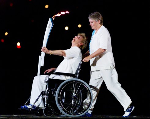 Betty Cuthbert, who suffered from multiple sclerosis, carries the torch during the Sydney Olympics opening ceremony in 2000. 