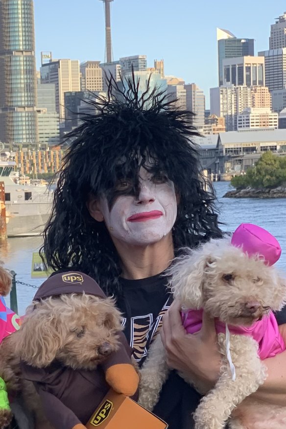 Chrysanthou dressed up as a member of the rock band, KISS, at a Halloween party, holding her dogs.