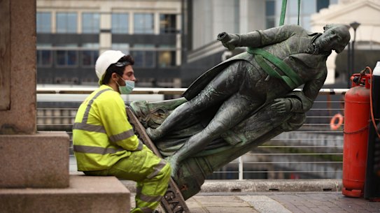 A worker rests after the statue of slave owner and West India Docks founder Robert Milligan was taken down in London.