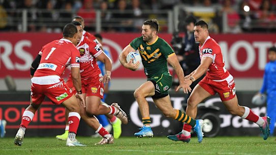 James Tedesco tries to evade Tongan defenders at Eden Park on Saturday night.