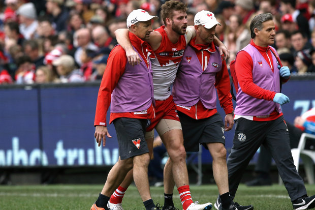 Alex Johnson is helped off the field after injuring his anterior cruciate ligament while playing for the Swans in 2018.