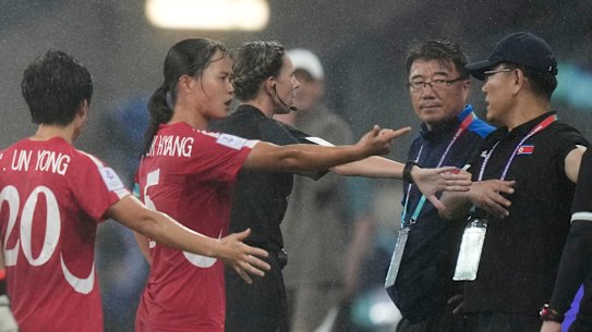 North Korean coaching staff and players argue with a match official after China’s second goal on Monday.