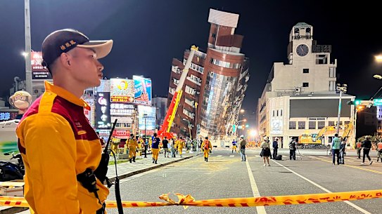 A rescue worker stands near the cordoned off site of a leaning building in the aftermath of an earthquake in Hualien, eastern Taiwan.