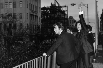 The Beatles wave to the fans from the first floor balcony of the Southern Cross Hotel, Melbourne.