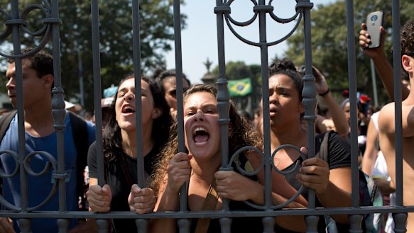 Students and National Museum employees protest outside the institution after it was gutted by fire.