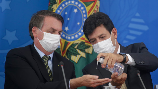 Mixed messages. President Jair Bolsonaro and Health Minister Luiz Henrique Mandetta on March 18.