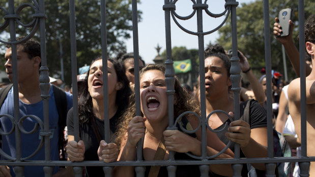 Students and National Museum employees protest outside the institution after it was gutted by fire.