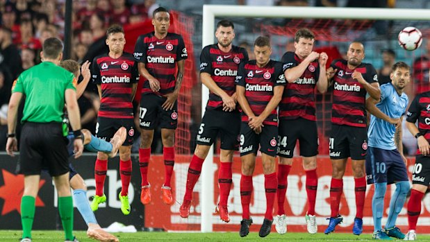 Late assault: Sydney FC try to bend a free kick around a Wanderers wall.