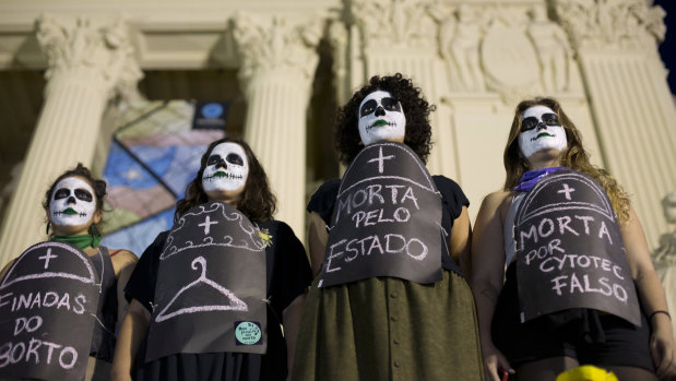 Pro-choice demonstrators wear signs that say in Portuguese: "Death by abortion" to protest against the deaths of women who died after illegal abortions. 