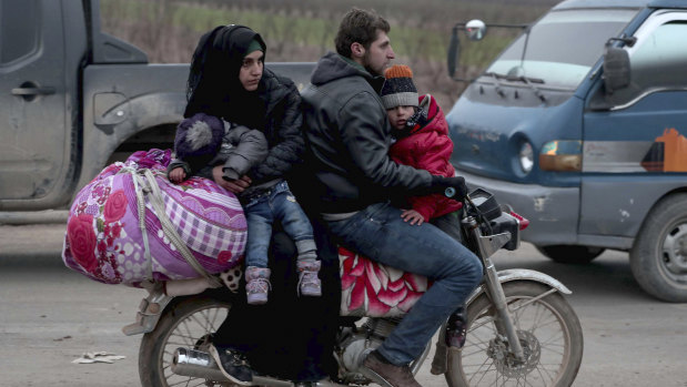 Civilians flee from Idlib to find safety inside Syria near the border with Turkey on Tuesday.