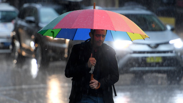 Pedestrians brave heavy rain on Friday afternoon. 