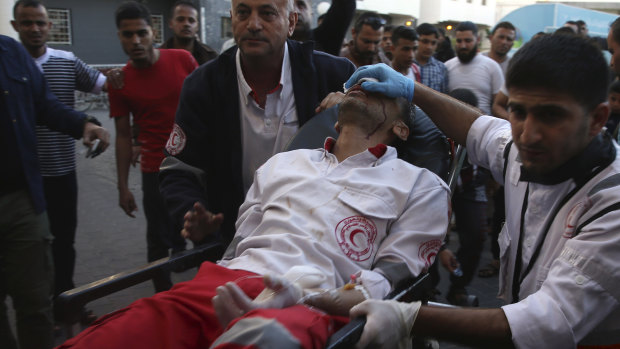 Medics move their wounded colleague, shot by Israeli troops during a protest at the Gaza Strip's border at Shifa hospital in Gaza City.