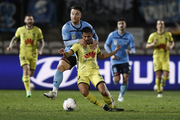 Sydney FC's Alex Baumjohann tackles Wellington Phoenix star Ulises Davila in last week's A-League restart.