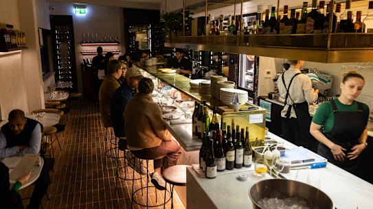 Behind the marble bench, chefs slice salumi and shuck oysters.