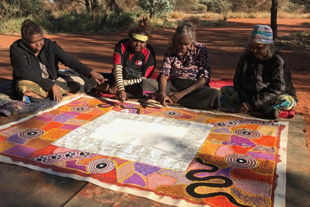 Lead artist Rene Kulitja (third from left) supervises artists Christine Brumby, Charmaine Kulitja and Happy Reid. 