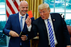 Donald Trump holds up a red card during a meeting with FIFA President Gianni Infantino in the Oval Office in 2018.