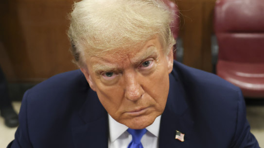 Former president Donald Trump, centre, awaits the start of proceedings at Manhattan criminal court in New York.