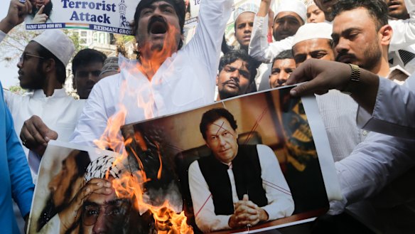 Indian muslims burn posters of Pakistani Prime Minister Imran Khan, centre, and Hafiz Saeed, chief of Pakistani religious group Jamaat-ud-Dawa, during a protest against Thursday's attack on a paramilitary convoy.