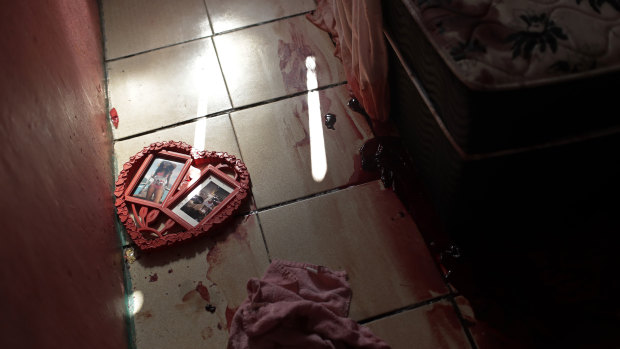 Blood covers the floor and a picture frame in a shape of a heart, inside a home during a police raid targeting drug traffickers in the Jacarezinho favela of Rio de Janeiro.