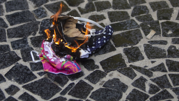 Protective masks are burned by supporters of Brazilian President Bolsonaro during a rally in favour of Bolsonaro's position that no one will be forced to use them and eventually get a coronavirus vaccine in Rio de Janeiro.