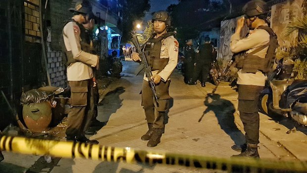 Armed police at a site where a suspected terrorist was shot dead and four members of his family apprehended after the Surabaya attacks.