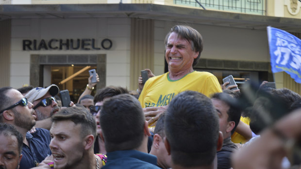 Başkan adayı Jair Bolsonaro, 2018'de Brezilya'nın Juiz de Fora kentinde düzenlenen bir kampanya mitingi sırasında karnından bıçaklandıktan sonra yüzünü buruşturdu.
