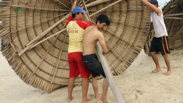 People remove beach cabanas ahead of typhoon Molave in Danang, Vietnam. The storm was expected the hit tourism areas hard.