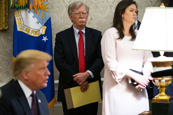 Former US president Donald Trump (left) and then national security adviser John Bolton with Sarah Huckabee Sanders in the Oval Office in 2019.