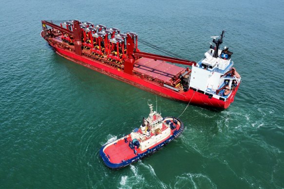 A Svitzer tug boat bringing a ship to port.