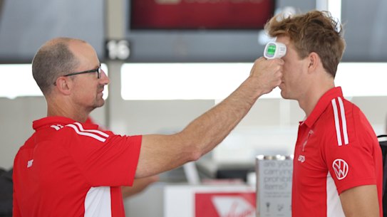 A Swans player having his temperature taken before the team boarded their flight to Adelaide on Friday.