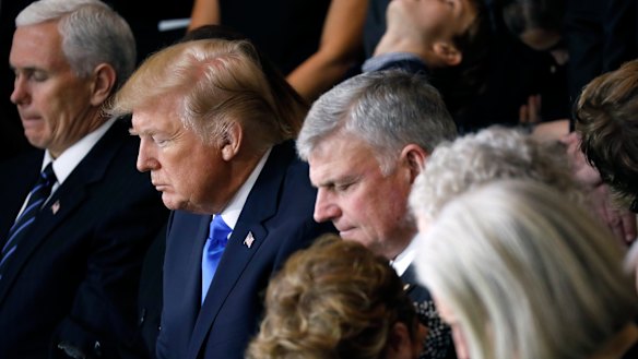 Franklin Graham (centre) and the Graham family pray alongside US President Donald Trump and Vice-President Mike Pence as Billy Graham lies in honour at the US Capitol in February 2018.