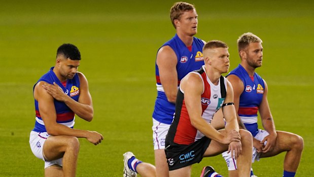 Mark of respect: Bulldogs' Jason Johannisen (left), Saints' Dan Hannebery and teammates take a knee before the round 2 match at Marvel Stadium.