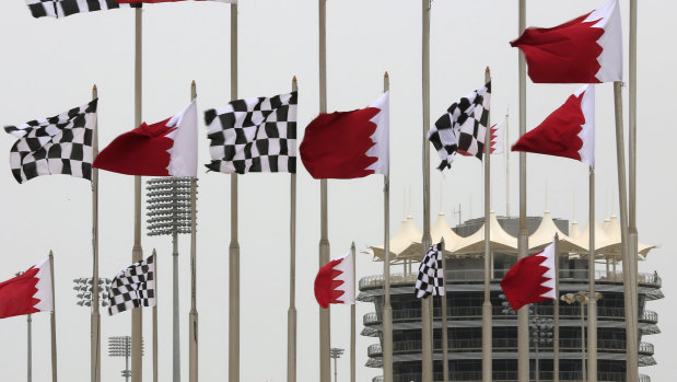 Bahraini and racing flags fly in front of the tower at the Bahrain International Circuit.