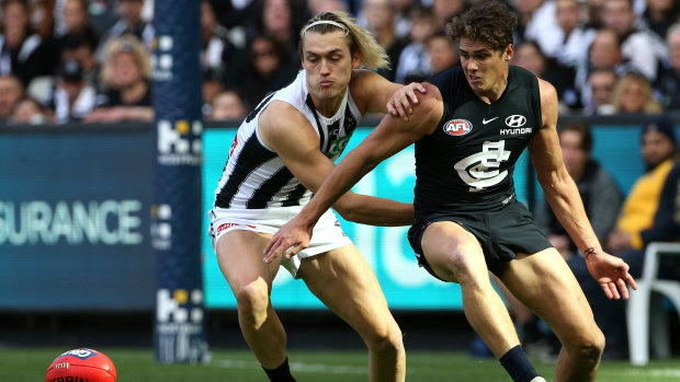 Darcy Moore of the Magpies, left, takes on Charlie Curnow of the Blues.