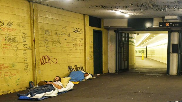 Two homeless people sleep near the entrance to St James railway station.