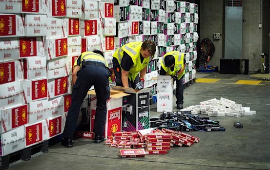Border Force officers check illegal cigarette imports found in shipping containers in Melbourne.
