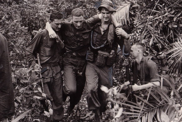 An Australian infantryman injured in a boobytrap bomb blast is helped to an evacuation helicopter  by fellow members Charlie Company, 5thb Royal Australian Regiment in November 1966. Peter Yule's book examines the experience of Vietnam veterans in Australia.
