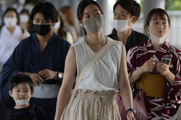 People pass through a pedestrian bridge in Yokohama, capital of Kanagawa prefecture. The prefecture is among three to join Tokyo in a state of emergency.