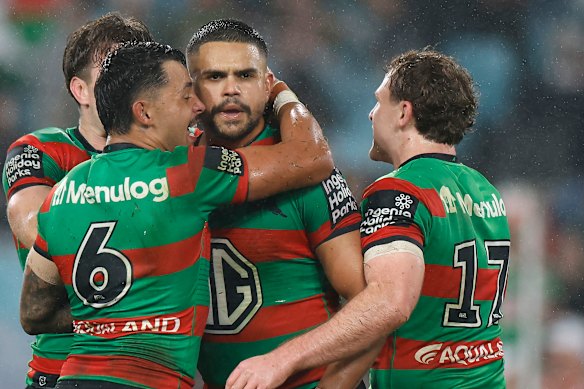 Latrell Mitchell is mobbed by his teammates.