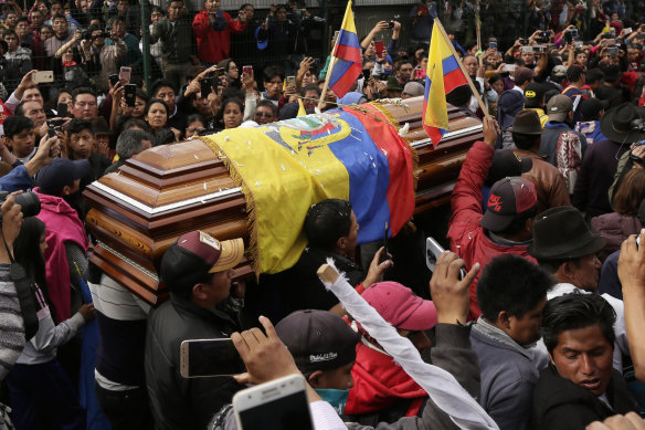 Anti-government protesters carry a coffin containing the remains of indigenous leader Inocencio Tucumbi, who protesters say died during the country's unrest. 