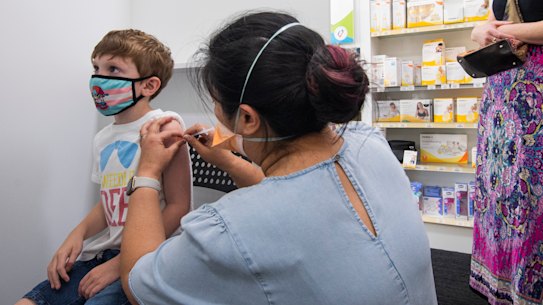 Christine Kelly administers a COVID vaccine to 7 year old Cohen Doherty, with mum Leanne looking on.