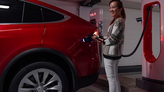 Vicky Wang charges her Tesla at Mirvac's Broadway shopping centre in Sydney. 