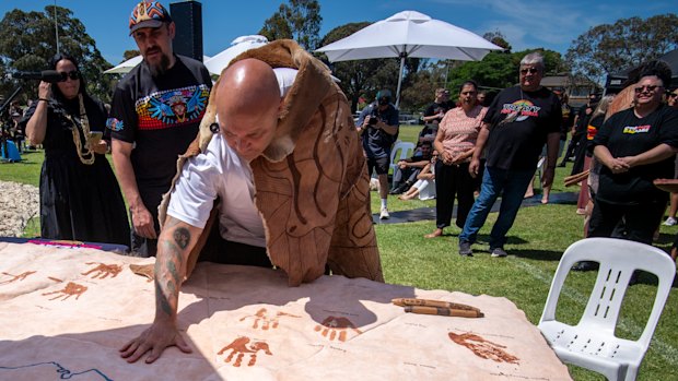 Mutti Mutti and Wamba Wamba man Jason Kelly puts his hand print on the kangaroo-skin treaty document.