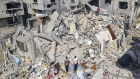 Palestinians look at the destruction after an Israeli airstrike in Rafah, Gaza.