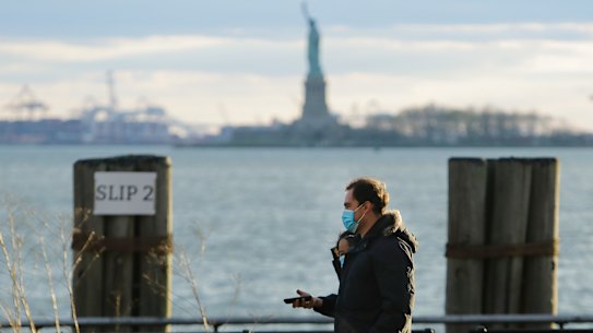 Pedestrians wear face masks while walking in Battery Park on Saturday, April 18, 2020, in the Manhattan borough of New York. (AP Photo/Frank Franklin II)
