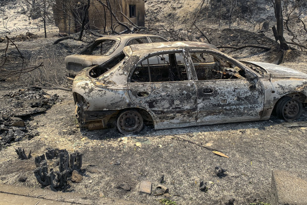 The gutted remains of cars lie on a road after a forest fire, on the island of Rhodes.